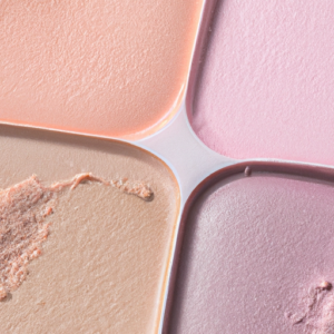 A horizontal close-up of a range of pastel-colored highlighter makeup swatches.