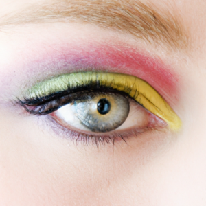 A close-up of a woman's eye with bright eyeshadow and a subtle hint of eyeliner.