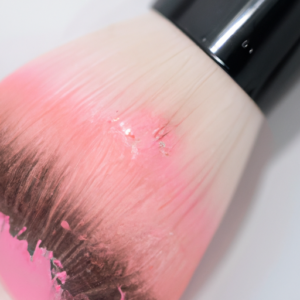 A close-up of pink and peach blush applied to a brush.