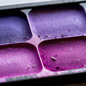 Close up of a pink and purple eyeshadow palette, with a few smudges of mascara on the brush.