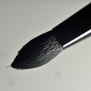 A close-up of a winged eyeliner brush, with a gradient of different shades of black and grey.