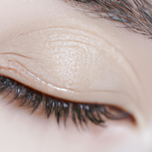 A close-up of an eye with a thin line of eyeliner on the eyelid.