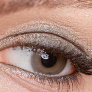 A close-up of a single eye with a soft, natural-looking smoky eye makeup, with a faint hint of mascara smudge underneath.