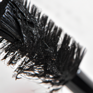 A close up of a makeup brush with a few mascara smudges on it.