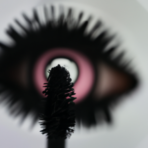 Suggestion: A close-up image of a mascara wand with a reflection of the eye in the bristles.