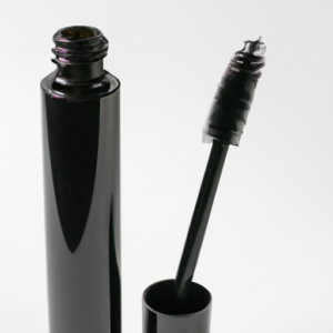 A tube of volumizing mascara with a mascara wand with curled lashes at the end.